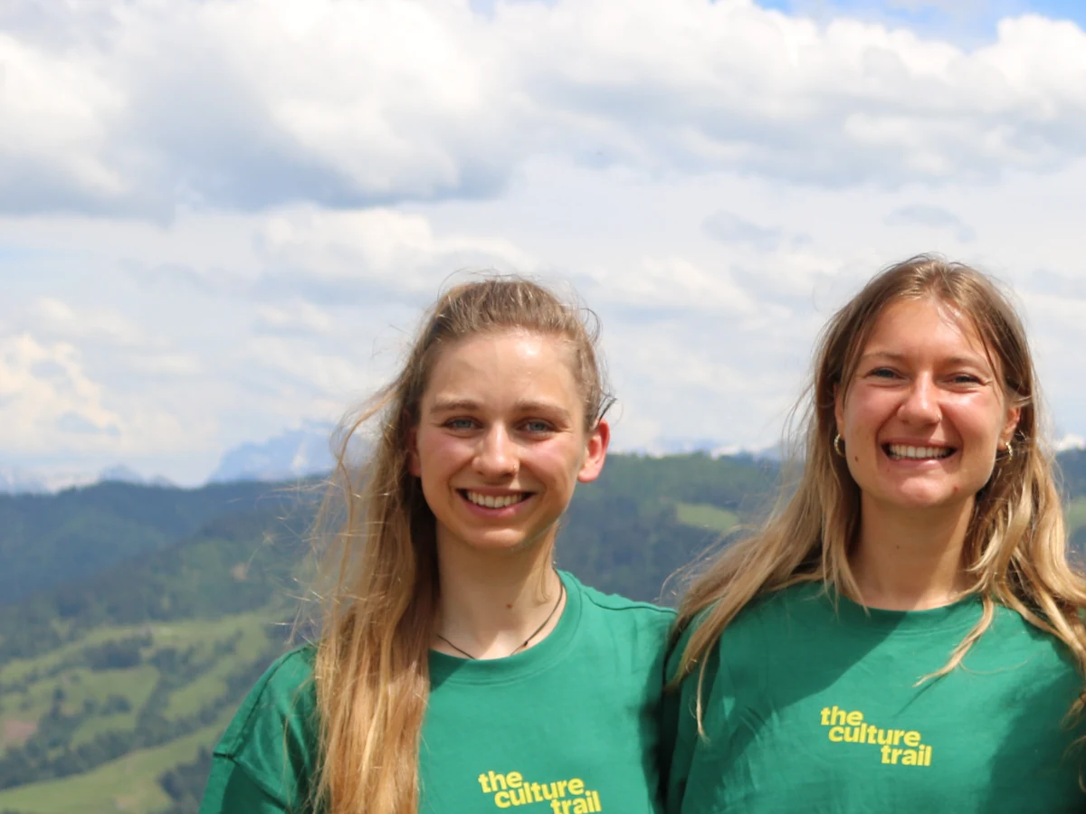 Ronja en Josien in shirts van The Culture Trail, met de bergen achter zich